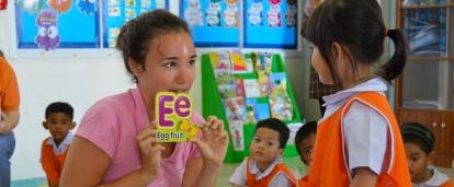 Projects Abroad volunteer teaching English in Thailand helps a young girl with her alphabet Volunteer gains teaching work experience in Thailand while working with children